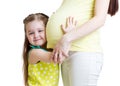 Cute child girl embracing pregnant mother