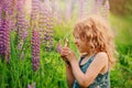 Cute child girl exploring nature with loupe on summer field Royalty Free Stock Photo