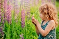 Cute child girl exploring nature with loupe on summer field Royalty Free Stock Photo