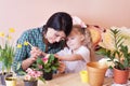 Cute child girl helps her mother to care for plants