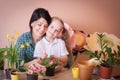 Cute child girl helps her mother to care for plants