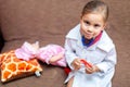 Cute child girl playing doctor with baby doll toy Royalty Free Stock Photo