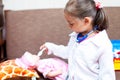 Cute child girl playing doctor with baby doll toy Royalty Free Stock Photo