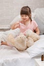 Cute child girl playing doctor with teddy bear Royalty Free Stock Photo