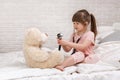 Cute child girl playing doctor with teddy bear Royalty Free Stock Photo