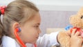 Cute child girl playing doctor with teddy bear Royalty Free Stock Photo