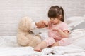 Cute child girl playing doctor with teddy bear Royalty Free Stock Photo