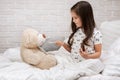 Cute child girl playing doctor with teddy bear Royalty Free Stock Photo