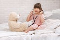 Cute child girl playing doctor with teddy bear Royalty Free Stock Photo