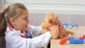 Cute child girl playing doctor with teddy bear Royalty Free Stock Photo