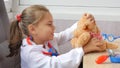 Cute child girl playing doctor with teddy bear Royalty Free Stock Photo