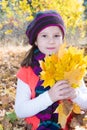 Cute child girl playing with fallen leaves in autumn Royalty Free Stock Photo