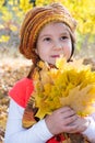 Cute child girl playing with fallen leaves in autumn Royalty Free Stock Photo