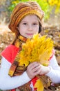 Cute child girl playing with fallen leaves Royalty Free Stock Photo
