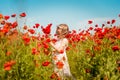 Cute child girl in poppy field gathering flowers. New generation and future. People and sustainable resources. Win