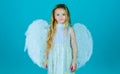 Cute child girl posing with angel wings. Beautiful little angel. Face of beautiful little angel girl on color background