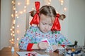 Cute child girl in seasonal sweater making Christmas post cards Royalty Free Stock Photo