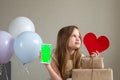 Cute child girl shows phone with green screen mock up cellphone, mobile, telephone and red heart. Chroma key green Royalty Free Stock Photo