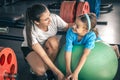 Cute child girl stretching on pilates fitness ball with mom in gym. Royalty Free Stock Photo