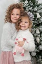 Cute child girls with sheep toy stand near Christmas tree Royalty Free Stock Photo