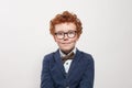 Cute child in glasses and blue suit portrait. Funny redhead boy on white background Royalty Free Stock Photo