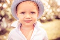 Cute child on the green grass in summer park. Baby face closeup. Funny little kid boy close up portrait. Blonde kid Royalty Free Stock Photo