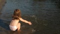 Cute child happily plays on the beach. baby splashing in the water. splashing water. happy child bathes in the sunset on