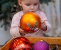 Cute child holding a big New Year's ball in his hands. A child looks delightedly at a huge shiny New Year's ball Royalty Free Stock Photo