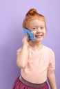 Cute child holding cell phone, smiling, having nice talk with someone