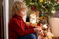 Cute child, holding sparkler at new year eve at home, sitting in front of the Christmas tree Royalty Free Stock Photo