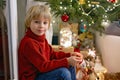 Cute child, holding sparkler at new year eve at home, sitting in front of the Christmas tree Royalty Free Stock Photo