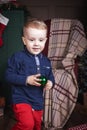 Cute child holding toy car near christmas decoration