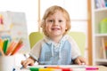 Cute child little boy drawing with felt-tip pen in kindergarten classroom Royalty Free Stock Photo