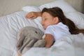 Cute child little girl sleeps in the bed with a toy elephant Royalty Free Stock Photo
