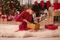 Cute child opening Christmas gift on floor at home Royalty Free Stock Photo