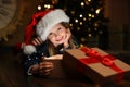 Cute child opening magic gift box near Christmas tree Royalty Free Stock Photo