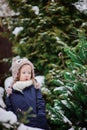 Cute child in owl knitted hat on the walk in winter snowy garden Royalty Free Stock Photo