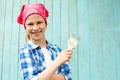 Cute child paints a wooden wall of blue paint. Idea of repair