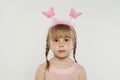 Cute child in pink hairband, portrait. Little girl in hairdeco on white background