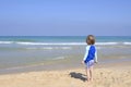 Cute child playing with car truck on sandy beach. Happy sailor boy on coast looking to the sea Royalty Free Stock Photo