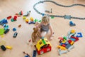 Cute child, playing with colorful toy blocks. Little boy building house of block toys sitting on the floor in sunny spacious Royalty Free Stock Photo