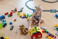 Cute child, playing with colorful toy blocks. Little boy building house of block toys sitting on the floor in sunny spacious Royalty Free Stock Photo