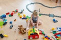 Cute child, playing with colorful toy blocks. Little boy building house of block toys sitting on the floor in sunny spacious Royalty Free Stock Photo