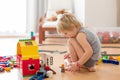 Cute child, playing with colorful toy blocks. Little boy building house of block toys sitting on the floor in sunny spacious Royalty Free Stock Photo