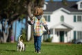 Cute child and puppy playing outside. Happy Kid boy and pet dog walking at backyard lawn. Royalty Free Stock Photo