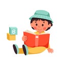 Cute child reading book, happy baby boy sitting on floor with open book and abc cubes Royalty Free Stock Photo