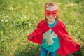 cute child in red superhero mask and cape standing