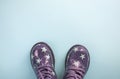 Cute child`s purple color shoes on blue background. Royalty Free Stock Photo
