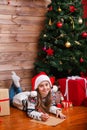 Cute child in Santa hat writes letter to Santa near christmas tree Royalty Free Stock Photo