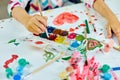 Cute child sitting at the table and drawing red heart on white paper Royalty Free Stock Photo